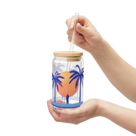 hand holding tropical glass sipper with reusable straw